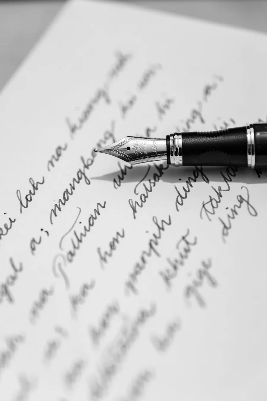 A fountain pen resting on a handwritten letter